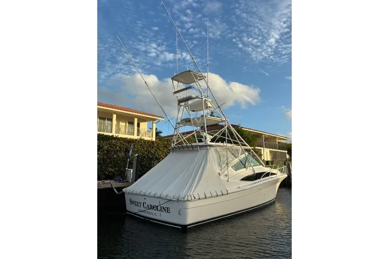 Slide: The Image of 2007 Bertram 360 boat docked, featuring a tall tower and covered deck. - 3