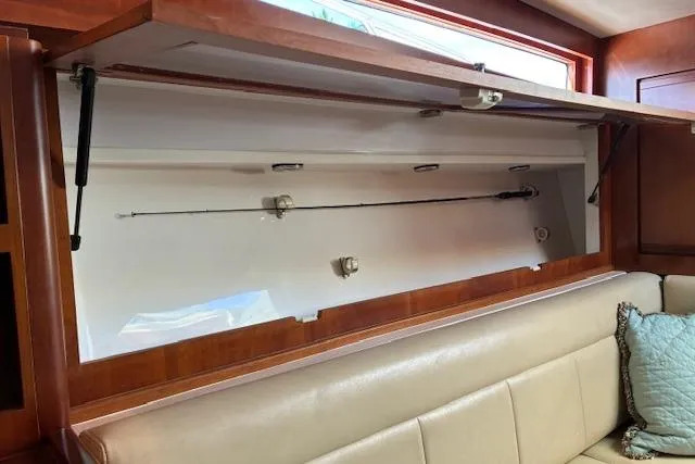 Slide: The Image of 2007 Bertram 360 interior with fishing rod storage above beige seating. - 34