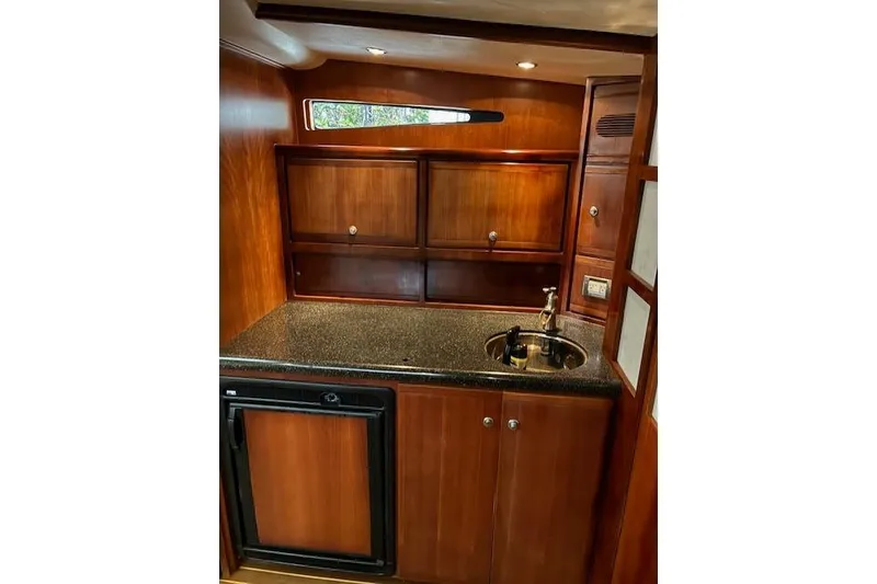 Slide: The Image of 2007 Bertram 360 yacht interior with wooden cabinetry and compact kitchenette. - 35