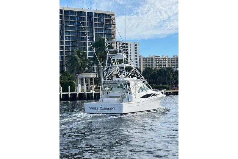 Slide: The Image of 2007 Bertram 360 boat named "Sweet Caroline" cruising near waterfront buildings. - 5