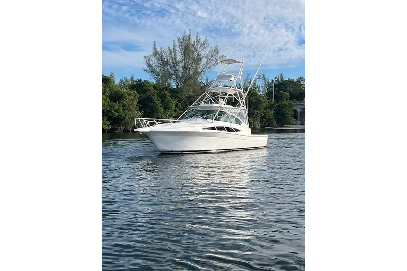 Slide: The Image of 2007 Bertram 360 boat on calm water with lush greenery background. - 6