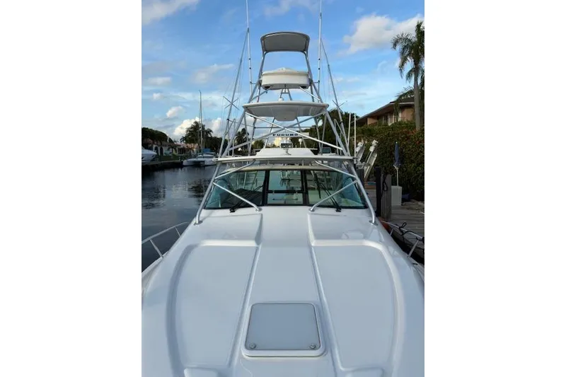 Slide: The Image of 2007 Bertram 360 boat docked, showcasing sleek design and multiple decks under a blue sky. - 9
