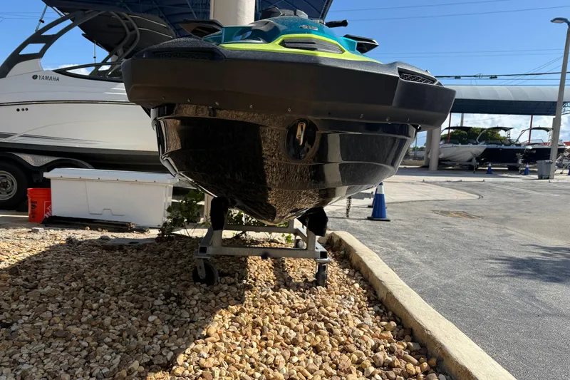 Slide: The Image of 2023 Kawasaki Ultra jet ski on display at a marina, parked on gravel. - 10