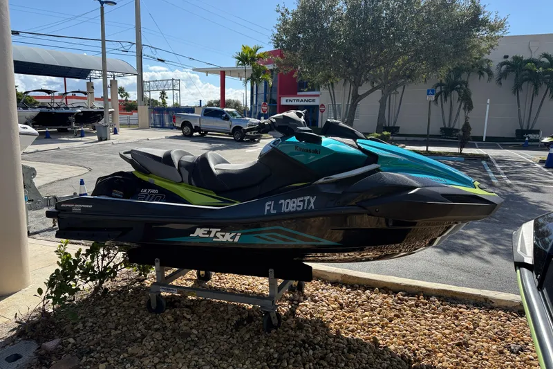 Slide: The Image of 2023 Kawasaki Ultra Jet Ski displayed outdoors on a stand. - 11