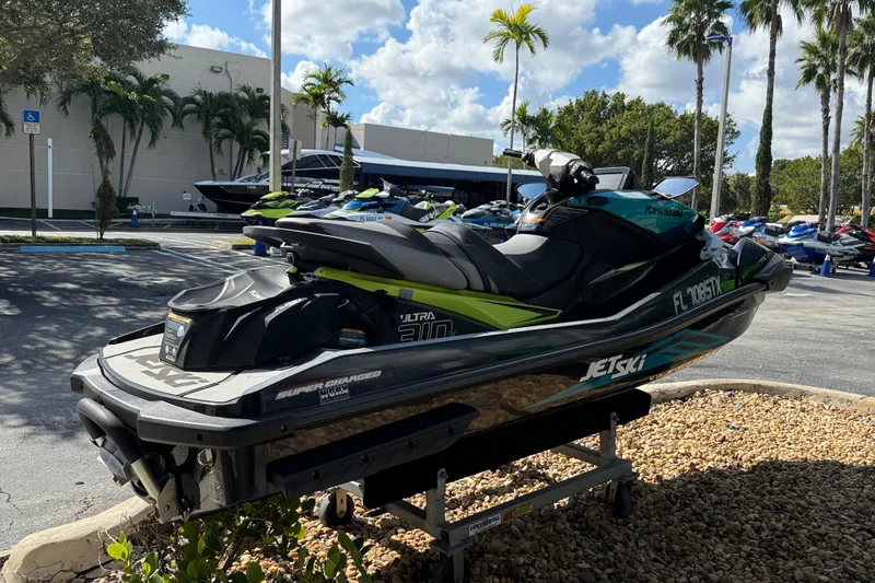 Slide: The Image of 2023 Kawasaki Ultra Jet Ski parked outdoors under palm trees. - 12