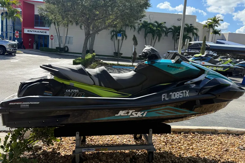 Slide: The Image of 2023 Kawasaki Ultra Jet Ski displayed outdoors on a stand, with a building in the background. - 3