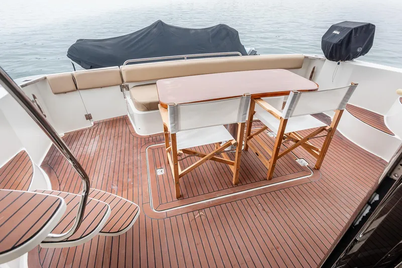 Slide: The Image of 2005 Carver 560 Voyager yacht deck with wooden flooring and seating area. - 25