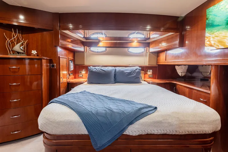 Slide: The Image of Luxurious 2005 Carver 560 Voyager yacht bedroom with elegant wood finish and cozy bedding. - 49