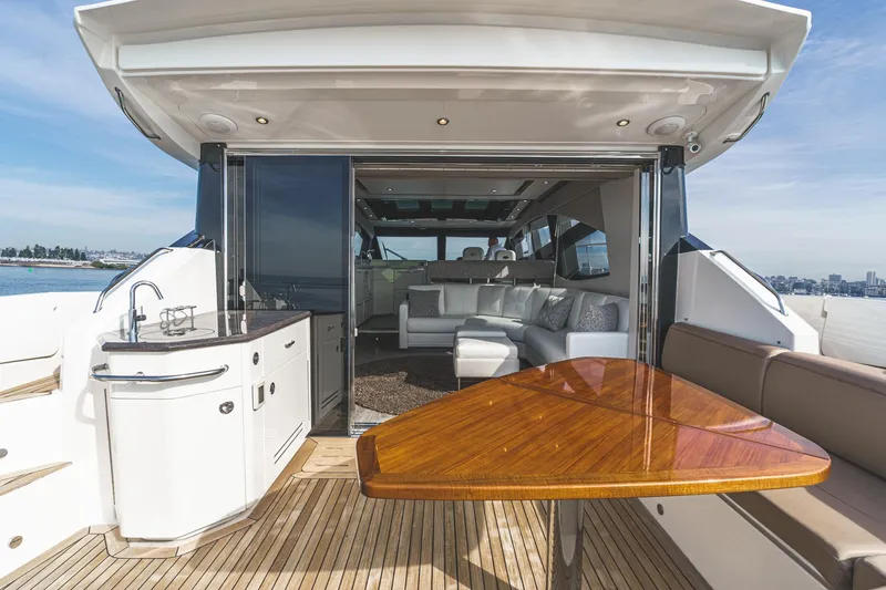 Slide: The Image of Luxurious 2016 Sea Ray L590 yacht interior with elegant seating and polished wood table. - 18