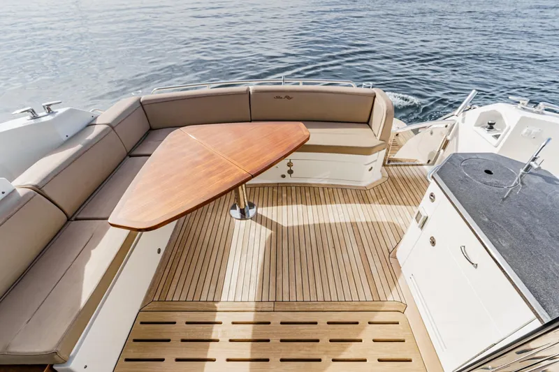Slide: The Image of Luxurious 2016 Sea Ray L590 yacht deck with seating and wooden table. - 20
