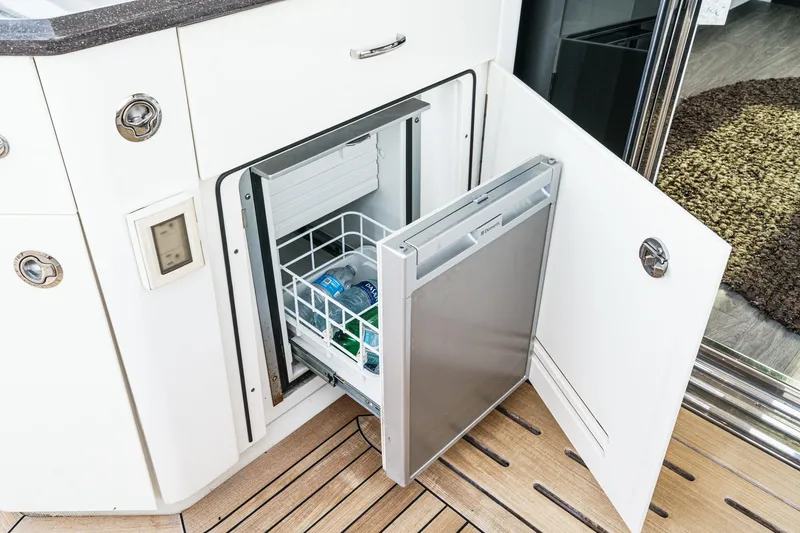 Slide: The Image of Built-in mini fridge on 2016 Sea Ray L590 yacht, stocked with drinks. - 23