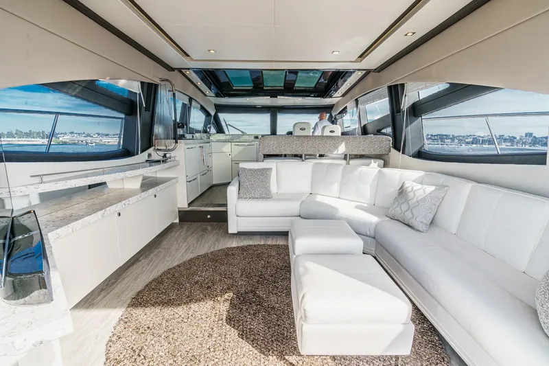 Slide: The Image of Luxurious interior of 2016 Sea Ray L590 yacht with white seating and panoramic windows. - 25
