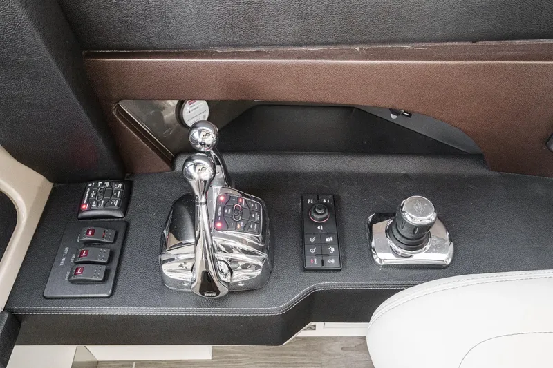 Slide: The Image of 2016 Sea Ray L590 yacht control panel with chrome levers and switches. - 44