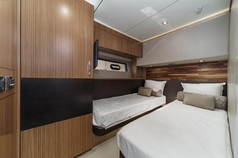 Slide: The Image of Luxurious 2016 Sea Ray L590 yacht cabin with twin beds and modern wood paneling. - 49