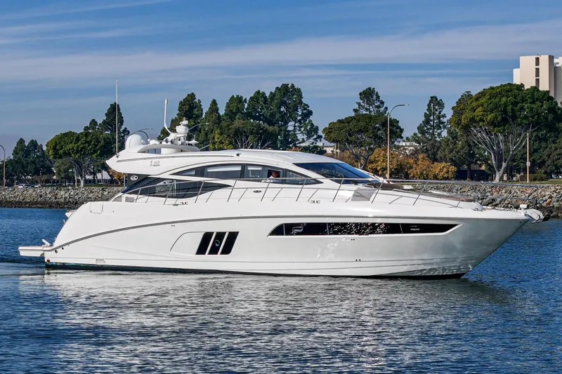 Slide: The Image of 2016 Sea Ray L590 yacht cruising on calm waters near a tree-lined shore. - 9