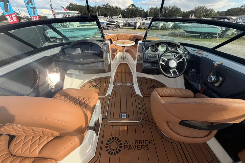 Slide: The Image of Interior of a 2016 Monterey 218 Surf boat with luxurious brown seating and modern dashboard. - 16