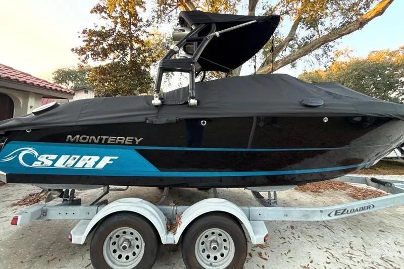 Slide: The Image of 2016 Monterey 218 Surf boat on trailer under clear blue sky. - 2