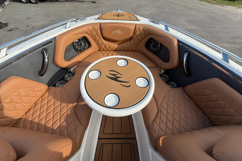 Slide: The Image of 2016 Monterey 218 Surf boat interior with tan leather seating and round table. - 21