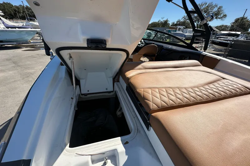 Slide: The Image of 2016 Monterey 218 Surf boat with open storage compartment and tan quilted seating. - 35