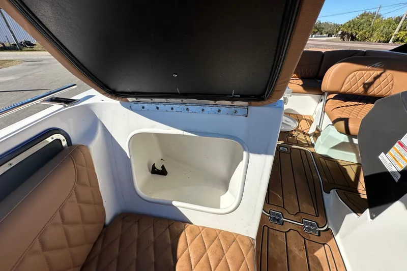 Slide: The Image of 2016 Monterey 218 Surf boat interior with tan quilted seats and storage compartment. - 47
