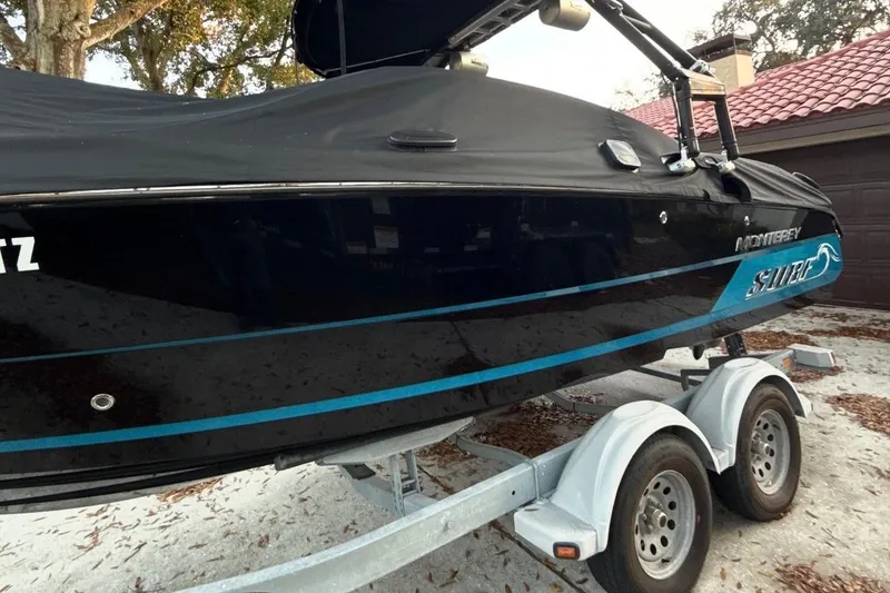 Slide: The Image of 2016 Monterey 218 Surf boat on trailer at Tampa dealership under clear blue sky. - 5