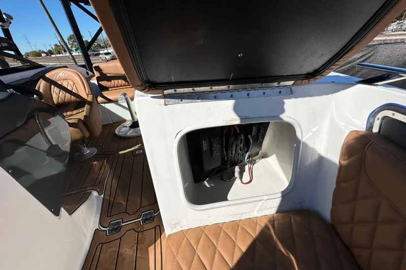 Slide: The Image of 2016 Monterey 218 Surf boat interior with open storage compartment and brown seating. - 50