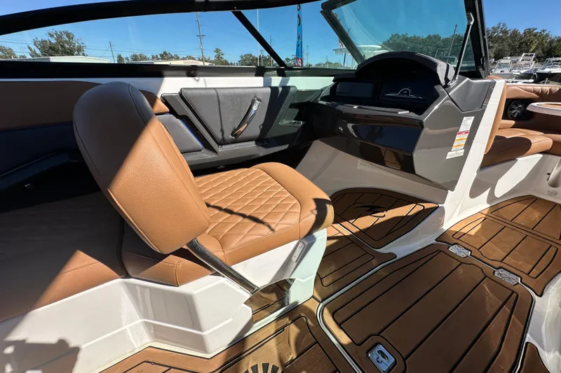 Slide: The Image of Interior of a 2016 Monterey 218 Surf boat with brown leather seating and wood-style flooring. - 58