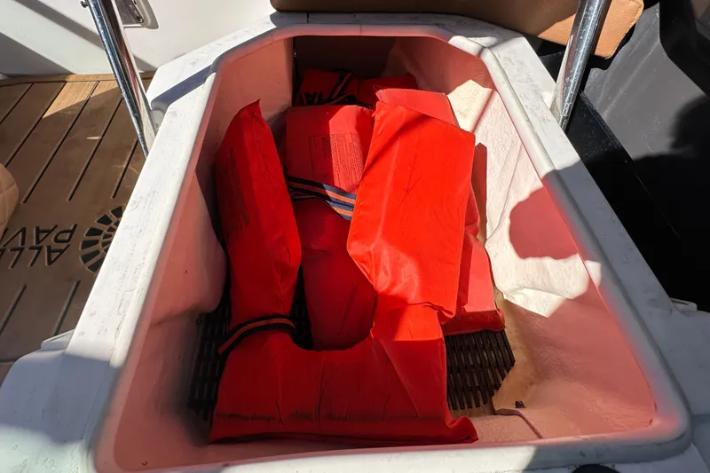 Slide: The Image of Storage compartment with red life jackets on a 2016 Monterey 218 Surf boat. - 62