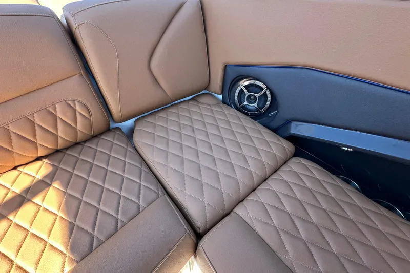 Slide: The Image of 2016 Monterey 218 Surf boat interior with brown quilted seats and speaker. - 63