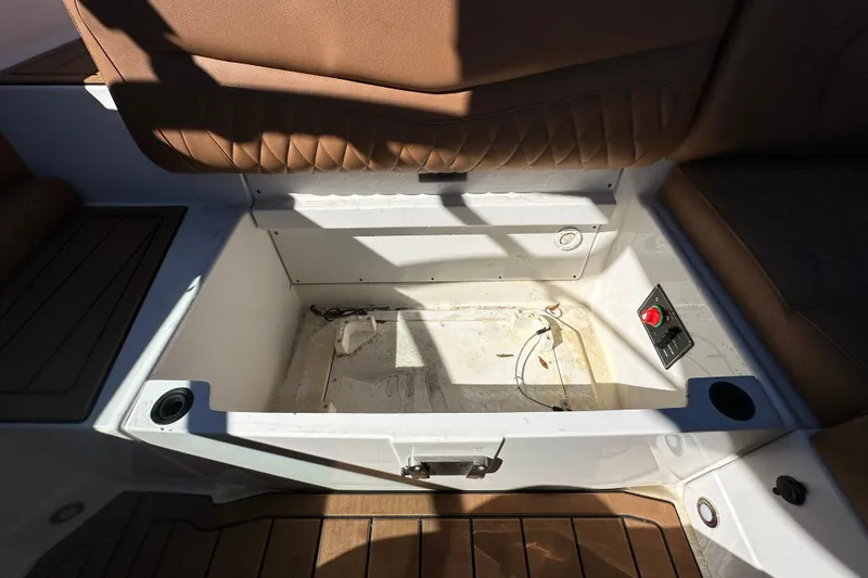 Slide: The Image of Open storage compartment in 2016 Monterey 218 Surf boat with brown seating. - 67