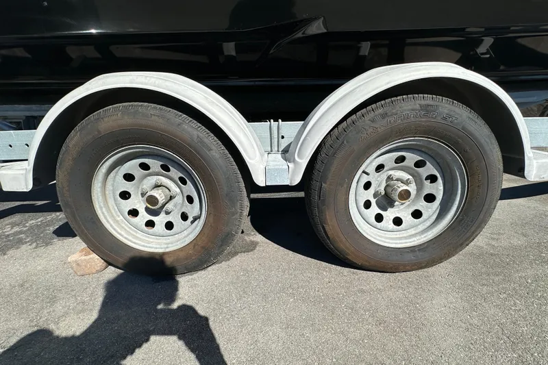 Slide: The Image of Trailer wheels of a 2016 Monterey 218 Surf boat on pavement. - 72