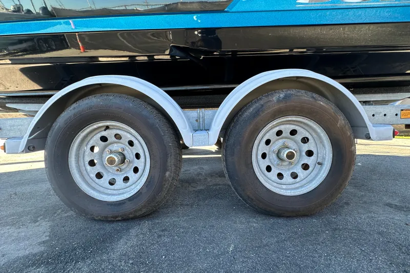 Slide: The Image of Trailer wheels of a 2016 Monterey 218 Surf boat on pavement. - 73