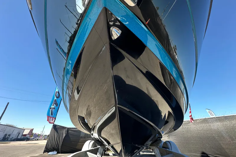 Slide: The Image of 2016 Monterey 218 Surf boat, sleek black and blue hull, displayed outdoors. - 74