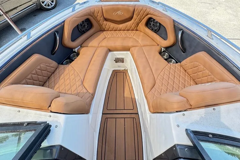 Slide: The Image of 2016 Monterey 218 Surf boat with tan seating and teak deck, displayed at a boat sale. - 9