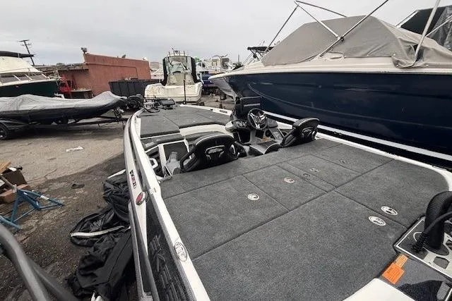 Slide: The Image of 2024 Skeeter FXR21 Limited boat in a marina, showcasing spacious deck and seating. - 15