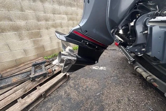 Slide: The Image of 2024 Skeeter FXR21 Limited boat motor detail, parked on concrete near wooden pallets. - 17