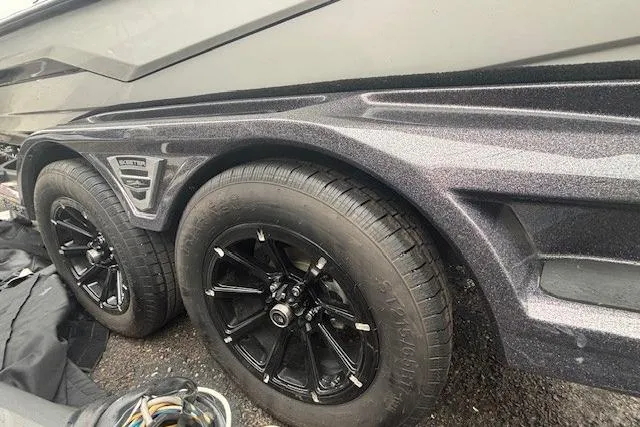 Slide: The Image of 2024 Skeeter FXR21 Limited trailer with black alloy wheels and sleek design. - 21