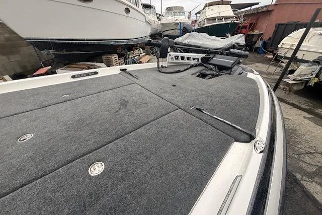 Slide: The Image of 2024 Skeeter FXR21 Limited boat deck with carpeted surface in a marina setting. - 6