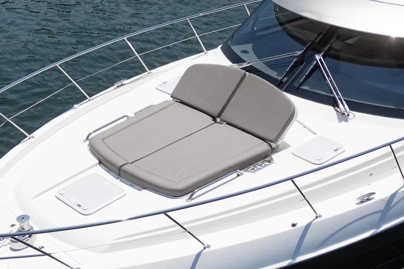 Slide: The Image of 2021 Riviera 4800 Sport Yacht with sunbed on deck, overlooking water. - 16
