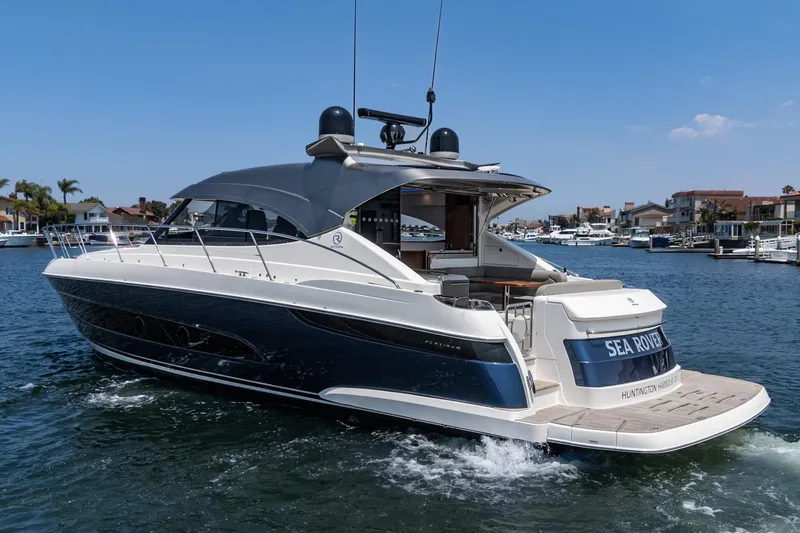Slide: The Image of 2021 Riviera 4800 Sport Yacht cruising in a marina, showcasing sleek design and luxury features. - 17