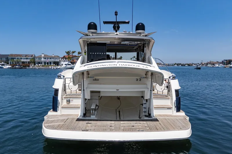 Slide: The Image of 2021 Riviera 4800 Sport Yacht docked at Huntington Harbour, CA, with open rear storage. - 20