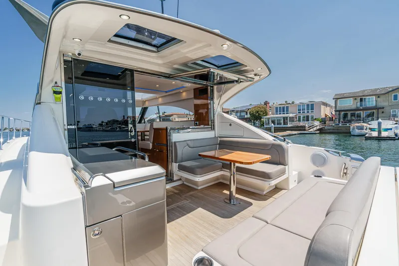 Slide: The Image of 2021 Riviera 4800 Sport Yacht with spacious outdoor seating and sleek design. - 23
