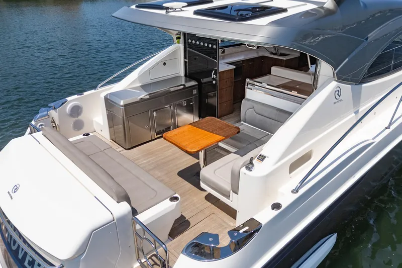 Slide: The Image of 2021 Riviera 4800 Sport Yacht with sleek deck and luxurious seating on water. - 24