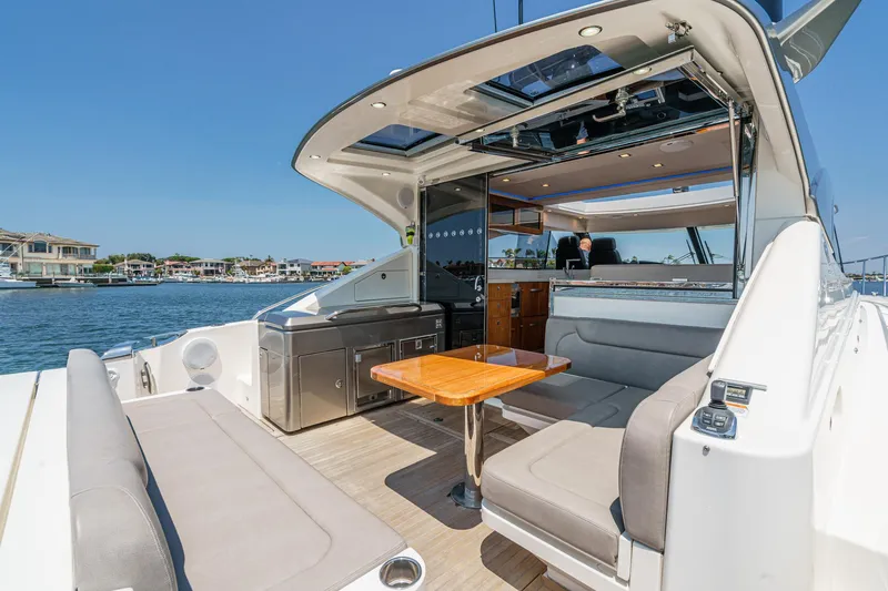 Slide: The Image of 2021 Riviera 4800 Sport Yacht with spacious outdoor seating and sleek interior design. - 25