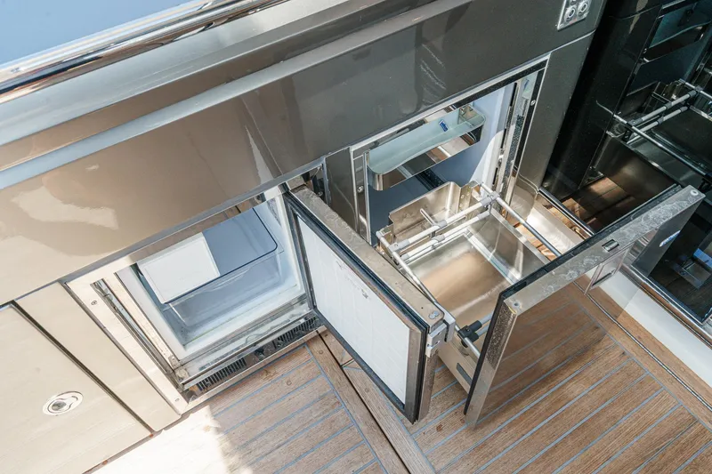 Slide: The Image of Open storage compartments on 2021 Riviera 4800 Sport Yacht, featuring sleek design and wooden flooring. - 29
