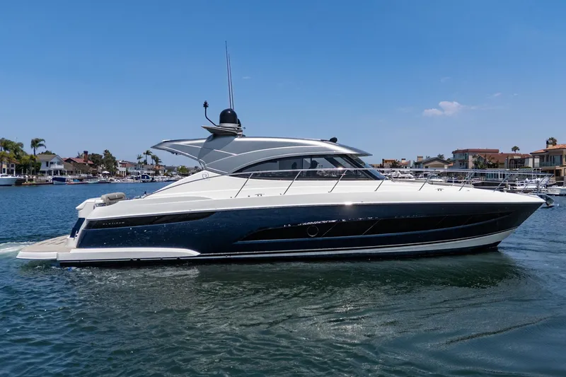 Slide: The Image of 2021 Riviera 4800 Sport Yacht cruising on a sunny day in a marina. - 3