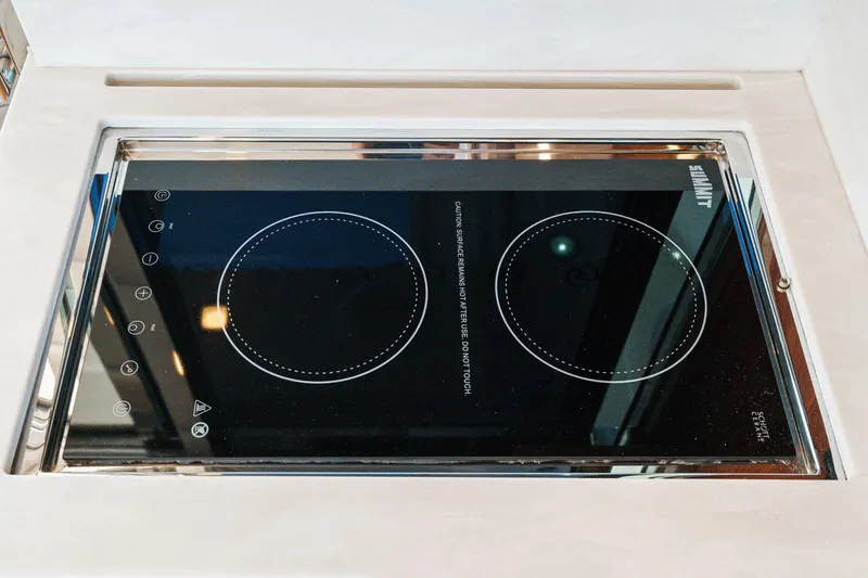 Slide: The Image of Induction cooktop on 2021 Riviera 4800 Sport Yacht, featuring sleek design and modern controls. - 37