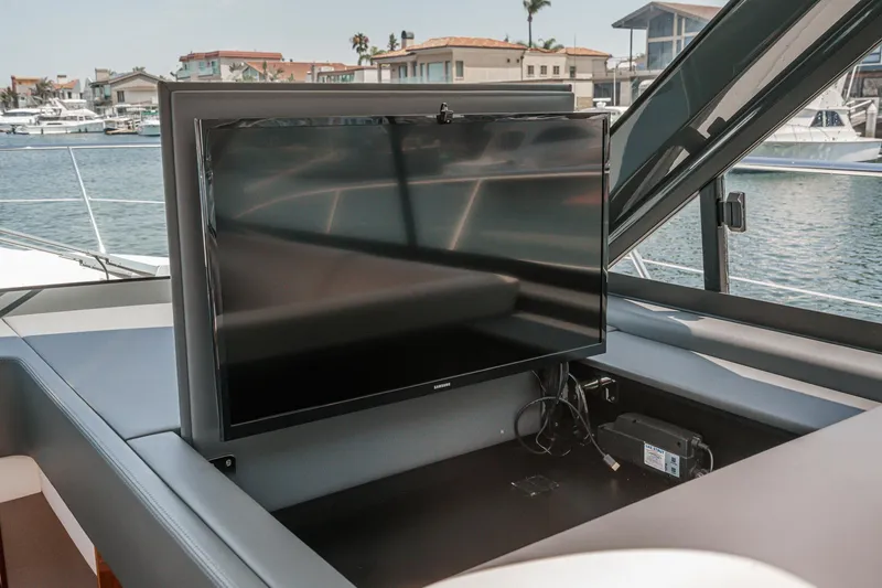 Slide: The Image of Riviera 4800 Sport Yacht 2021 with retractable TV on deck, marina view. - 42