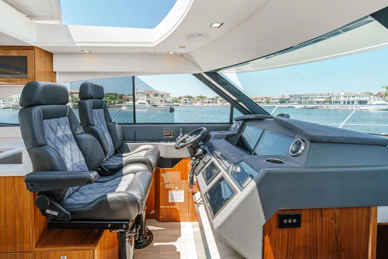 Slide: The Image of Interior of 2021 Riviera 4800 Sport Yacht with luxurious seating and modern dashboard. - 44