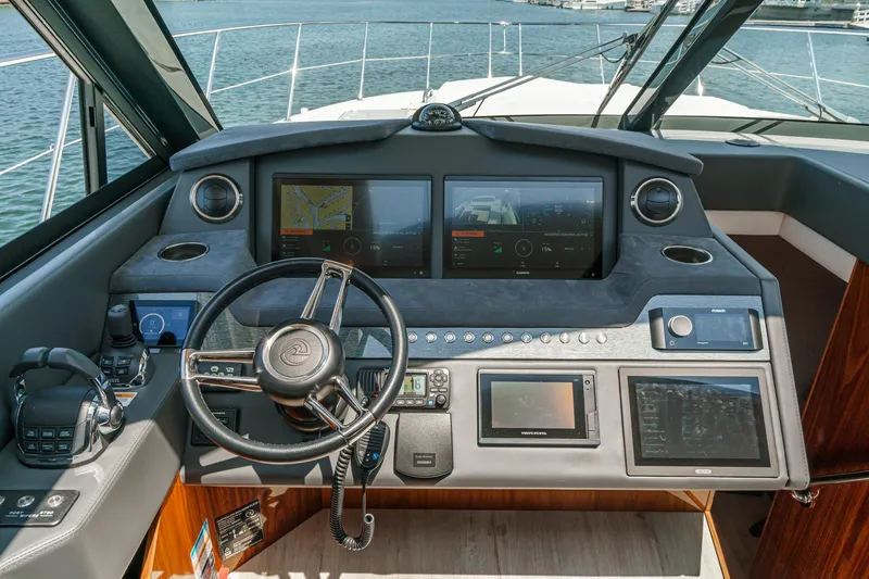 Slide: The Image of Helm of 2021 Riviera 4800 Sport Yacht with advanced navigation displays and controls. - 46